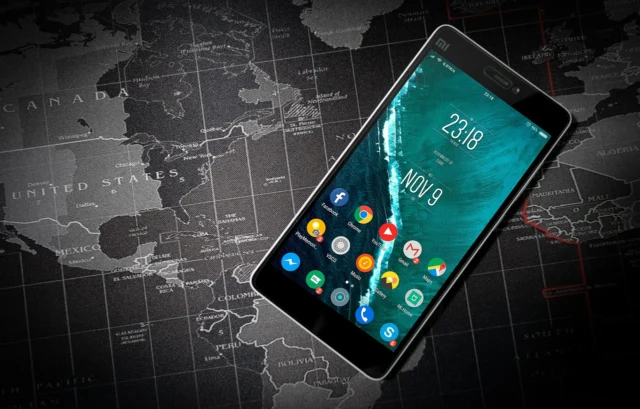 A person holding a smartphone displaying a flight tracking map with an estimated arrival time