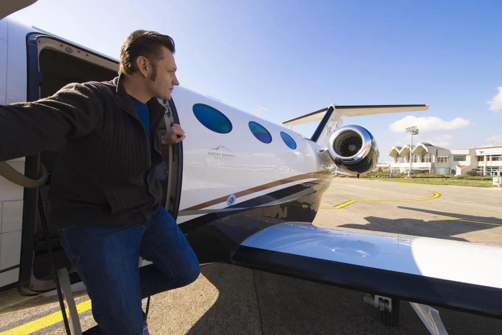 Person holding smartphone showing flight tracking app with private jet route